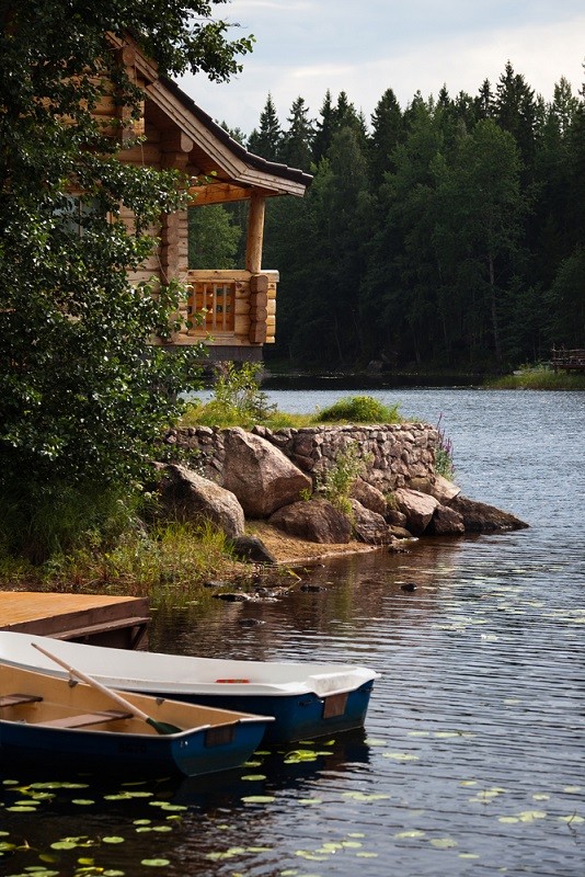 Two boats docked near a wooden cabin.