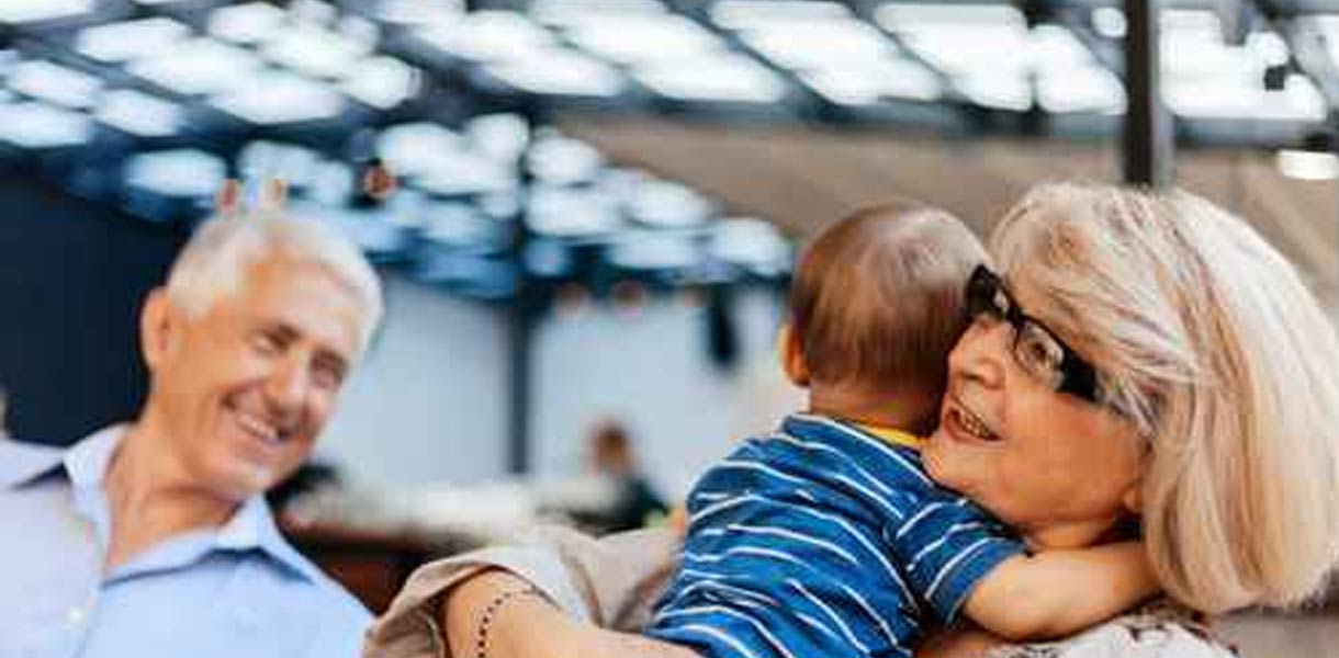 A woman hugs a toddler, smiling.