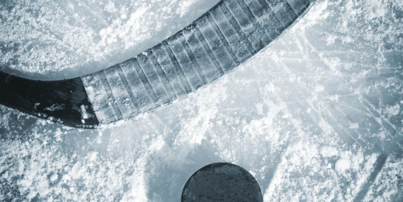 Black color hockey stick puck on ice